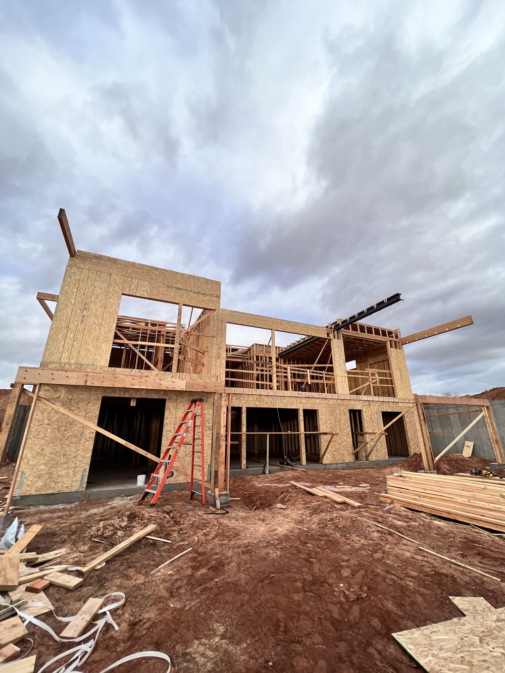 Two-story wood frame with open walls under a cloudy sky